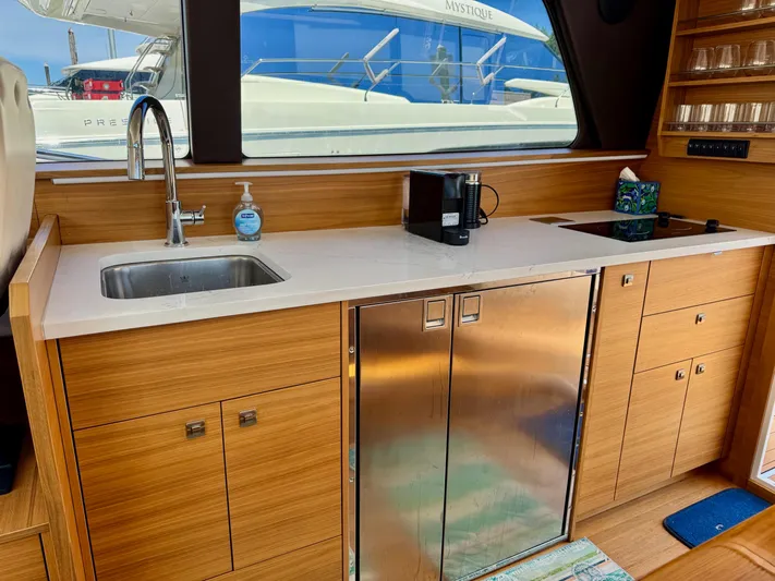 Nirvana Yacht Photos Pics Modern kitchen interior of 2020 Coastal Craft 33 Express yacht with wood cabinetry and stainless steel appliances.