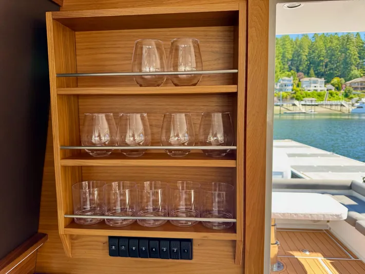 Nirvana Yacht Photos Pics Glassware shelf on 2020 Coastal Craft 33 Express yacht, overlooking serene waterfront.