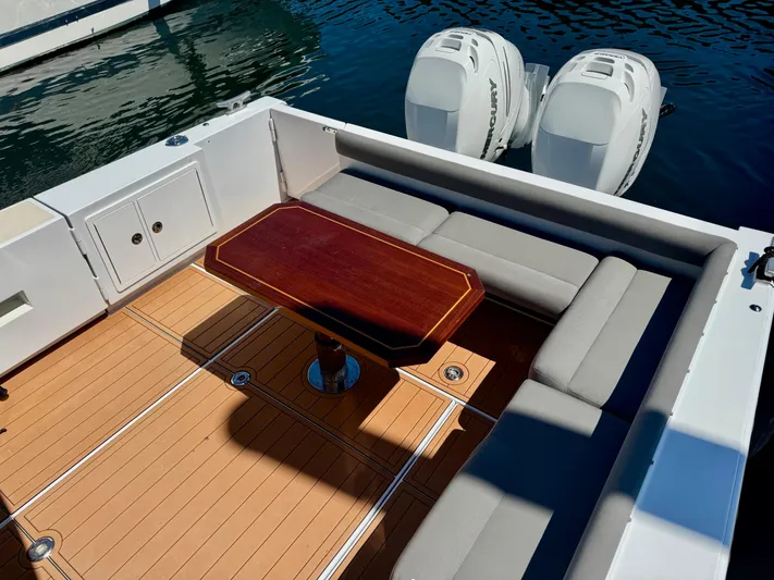 Nirvana Yacht Photos Pics 2020 Coastal Craft 33 Express boat with teak deck, cushioned seating, and dual outboard engines.