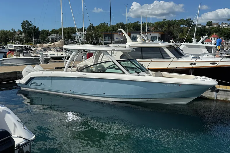  Yacht Photos Pics 2022 Boston Whaler 320 Vantage docked at a marina under a clear blue sky.