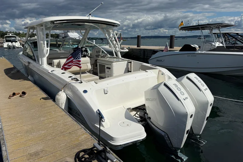  Yacht Photos Pics 2022 Boston Whaler 320 Vantage docked, featuring dual Mercury V8 engines and American flag.