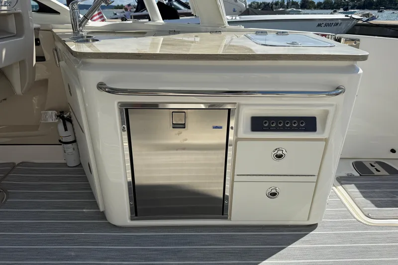  Yacht Photos Pics 2022 Boston Whaler 320 Vantage boat interior with kitchenette and storage drawers.