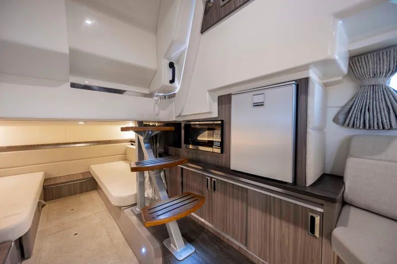  Yacht Photos Pics Interior of 2020 Sea Ray Sundancer 320 Outboard, featuring modern seating and compact kitchenette.