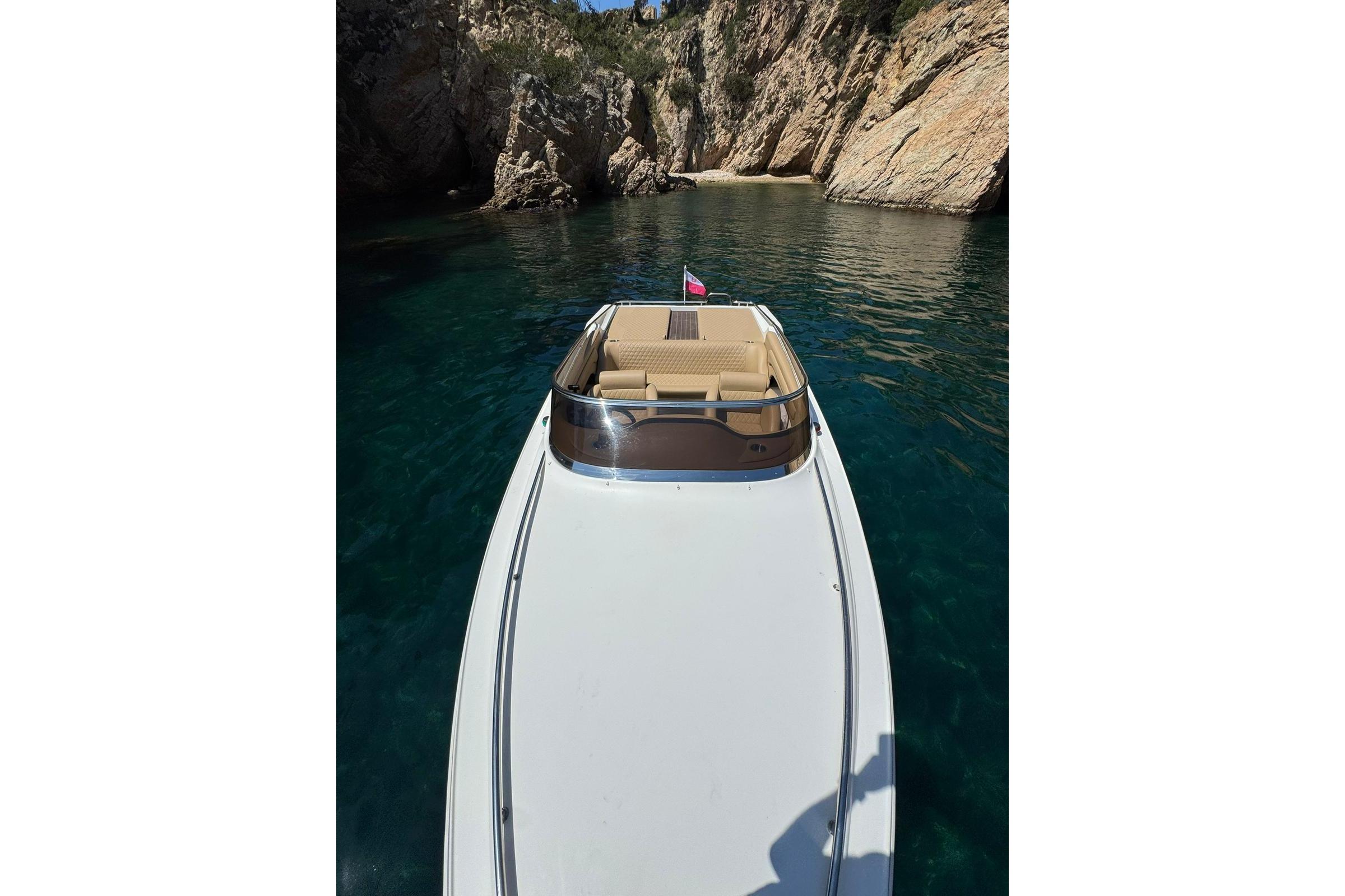 Performance 607 boat from 2000 in a scenic rocky cove with clear blue water.