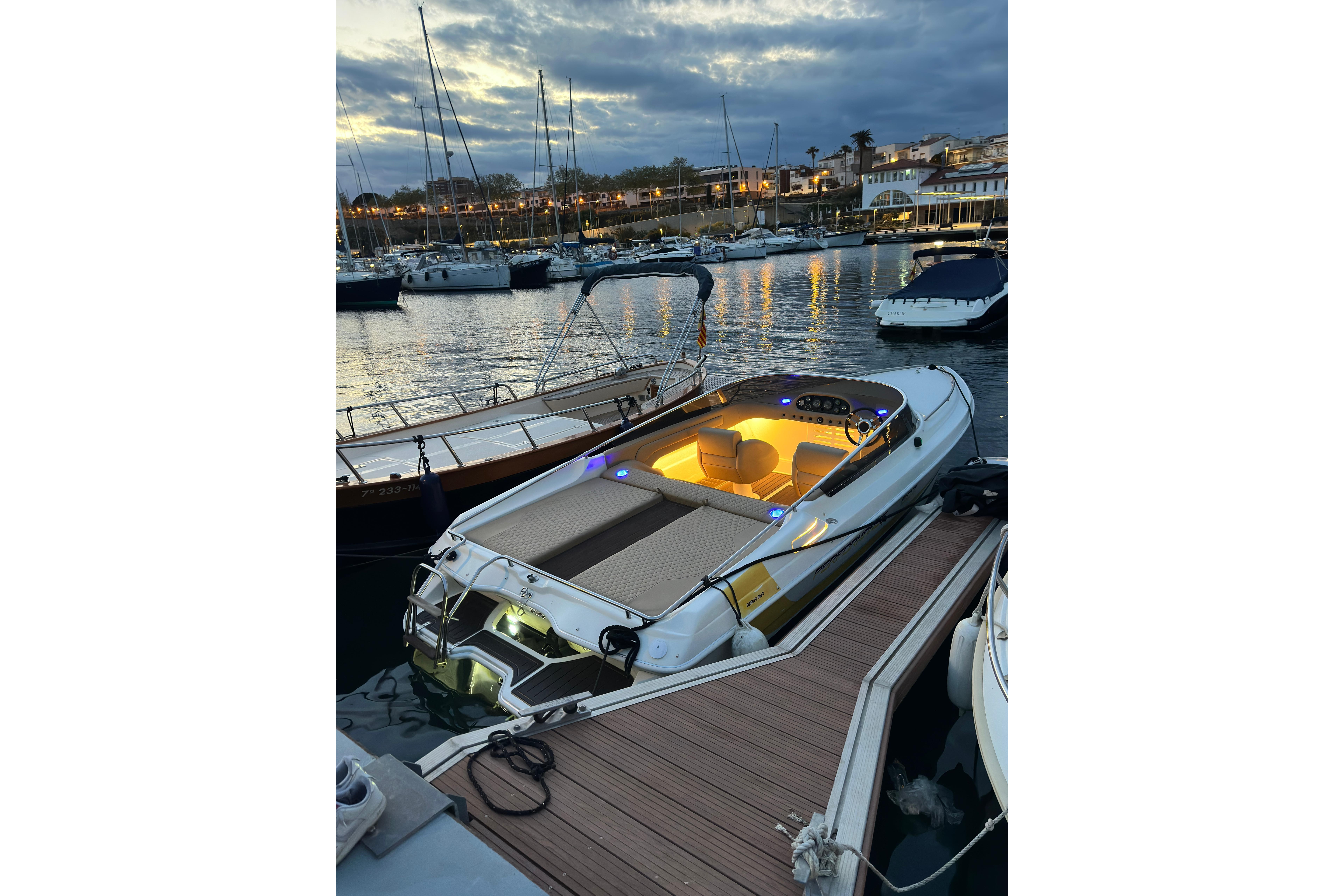 Luxury Performance 607 boat docked at sunset, illuminated interior, 2000 model.