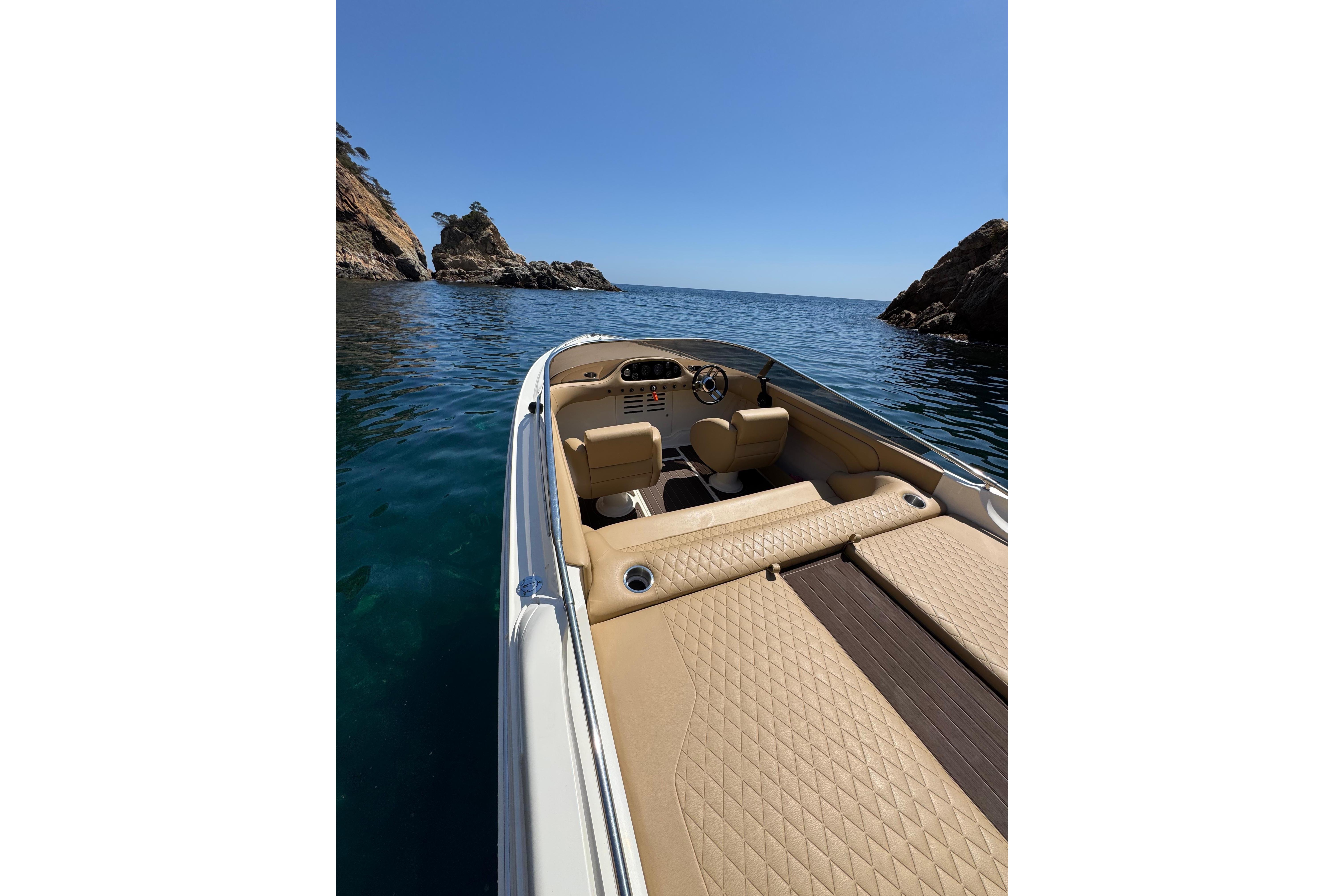 Luxury Performance 607 boat cruising between rocky cliffs, 2000 model.