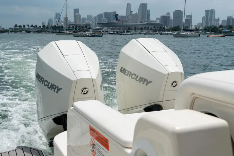  Yacht Photos Pics 2022 Sea Ray SDX 290 Outboard with twin Mercury engines cruising near city skyline.