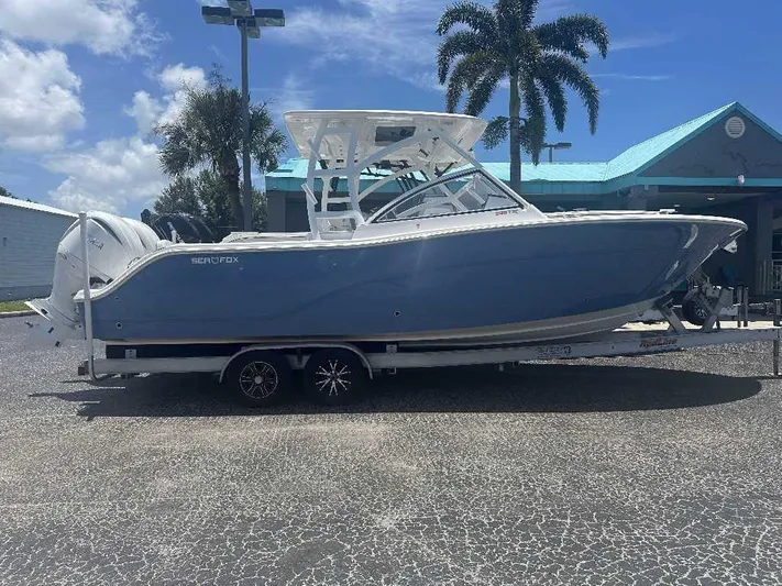 Black Label Marine Yacht Photos Pics 2026 Sea Fox 288 Traveler boat on trailer, parked outdoors under clear sky.