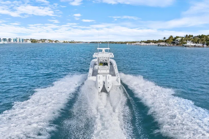  Yacht Photos Pics 2026 Yellowfin 32 Offshore boat cruising on clear blue water, leaving a wake behind.