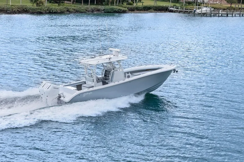  Yacht Photos Pics 2026 Yellowfin 32 Offshore boat cruising on a serene blue lake.