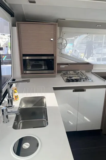 Scarlet Ibis Yacht Photos Pics Modern kitchen interior of 2023 Fountaine Pajot Isla 40 catamaran with sleek countertops and appliances.