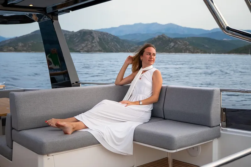  Yacht Photos Pics Woman relaxing on Beneteau Grand Trawler 63 yacht, scenic ocean view, 2026 model.