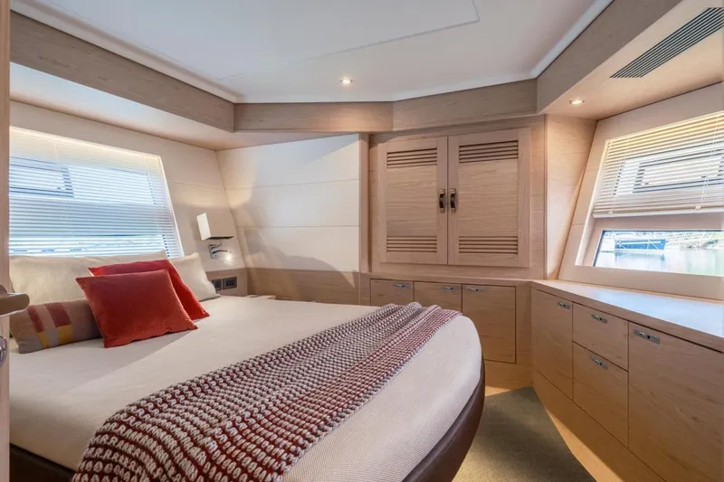  Yacht Photos Pics Luxurious bedroom interior of 2026 Beneteau Grand Trawler 63 with modern design and cozy decor.