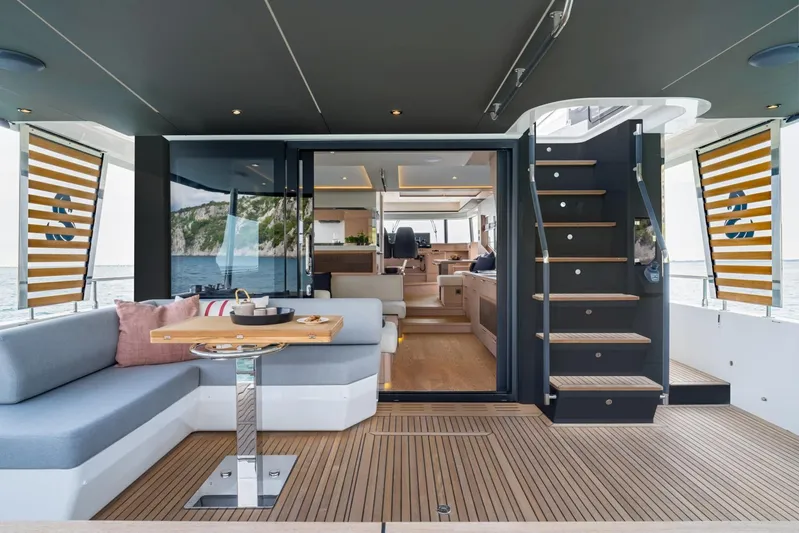 Yacht Photos Pics Luxurious interior of 2026 Beneteau Grand Trawler 63 yacht with elegant seating and wooden flooring.