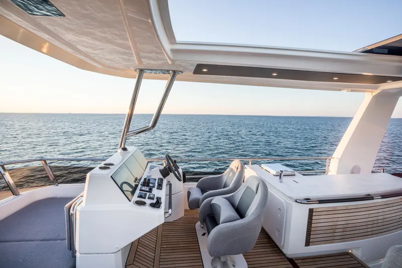  Yacht Photos Pics Flybridge of 2026 Beneteau Grand Trawler 63 with ocean view, featuring helm and seating area.