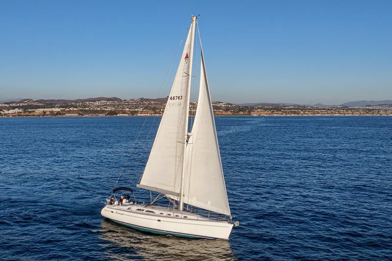 Firelight Yacht Photos Pics Sailboat Catalina 470, 1999 model, cruising on open sea with coastal background.