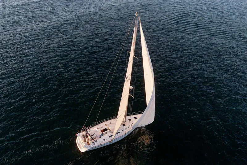 Firelight Yacht Photos Pics Aerial view of 1999 Catalina 470 sailboat navigating calm ocean waters.