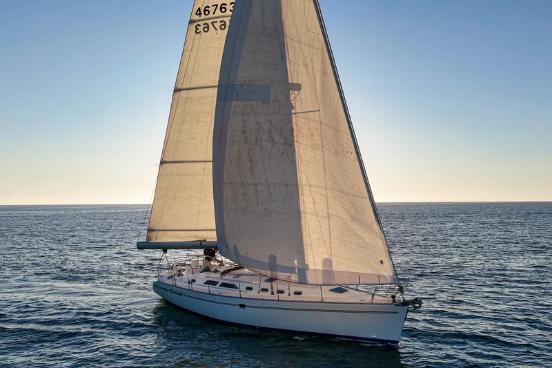 Firelight Yacht Photos Pics Sailing yacht Catalina 470 from 1999 gliding on open sea at sunset.