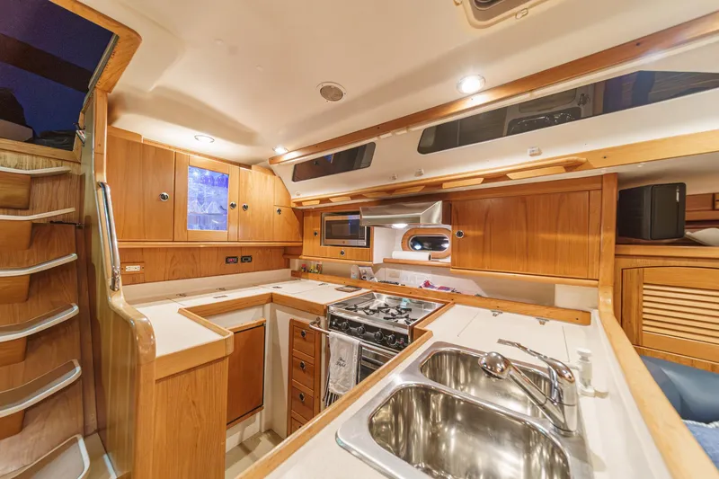 Firelight Yacht Photos Pics Interior of a 1999 Catalina 470 yacht kitchen with wooden cabinetry and modern appliances.