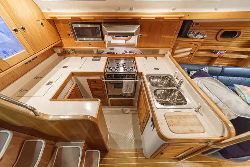 Firelight Yacht Photos Pics Interior of 1999 Catalina 470 yacht kitchen with wooden cabinetry and modern appliances.