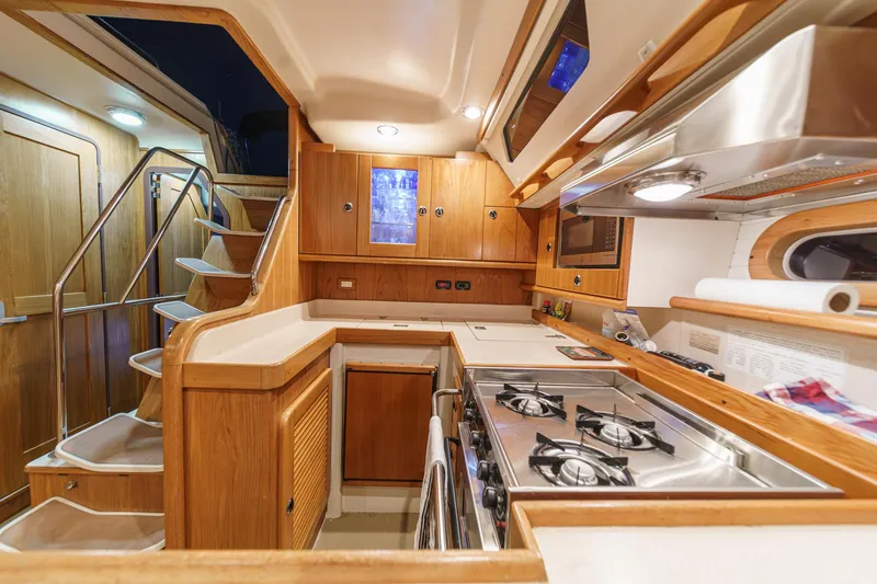 Firelight Yacht Photos Pics Interior of 1999 Catalina 470 yacht kitchen with wooden cabinetry and modern appliances.