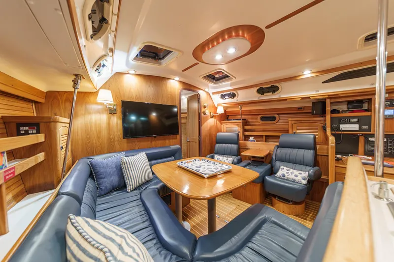 Firelight Yacht Photos Pics Luxurious interior of a 1999 Catalina 470 yacht with blue leather seating and wooden accents.