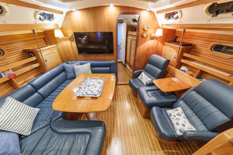 Firelight Yacht Photos Pics Luxurious interior of 1999 Catalina 470 yacht with plush seating and wooden finishes.