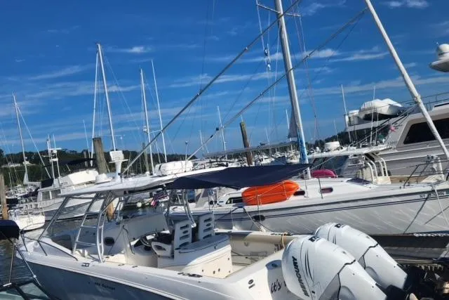  Yacht Photos Pics 2006 Boston Whaler 320 Outrage Cuddy Cabin docked at a marina under clear blue skies.