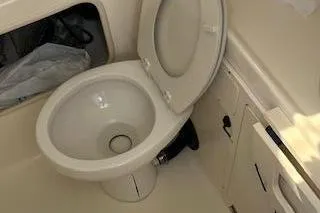  Yacht Photos Pics 2006 Boston Whaler 320 Outrage Cuddy Cabin bathroom with toilet and storage.