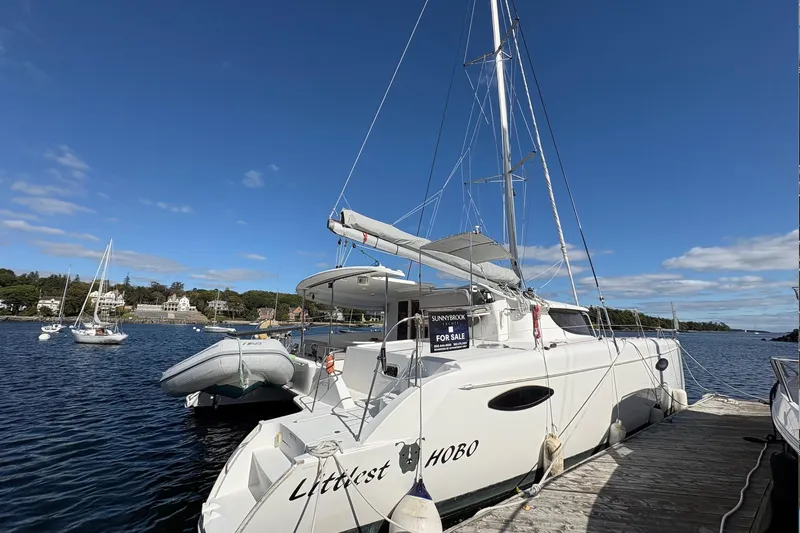 Littlest Hobo Yacht Photos Pics 2009 Fountaine Pajot Orana 44 Maestro catamaran docked, for sale, under clear blue sky.
