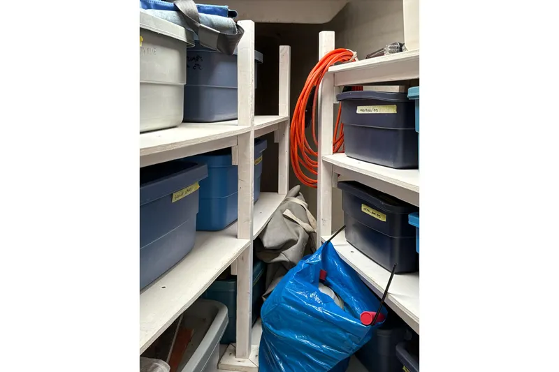 Littlest Hobo Yacht Photos Pics Storage area on a 2009 Fountaine Pajot Orana 44 Maestro, with labeled bins and equipment.