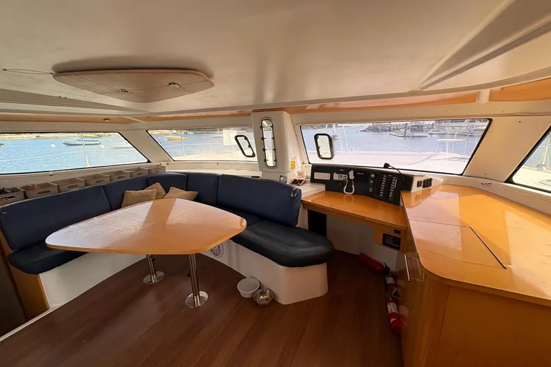 Littlest Hobo Yacht Photos Pics Interior of 2009 Fountaine Pajot Orana 44 Maestro, featuring a spacious seating area and navigation station.