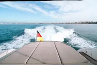 2016 Princess V48 Open yacht cruising with city skyline in the background.