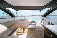 Luxurious 2016 Princess V48 Open yacht interior with seating and table, overlooking serene waters.