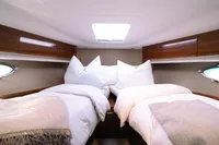 Luxurious cabin interior of 2016 Princess V48 Open yacht with twin beds and elegant wood finish.