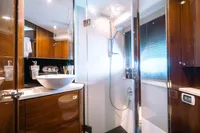 Luxurious bathroom interior of 2016 Princess V48 Open yacht, featuring modern fixtures and elegant wood finishes.