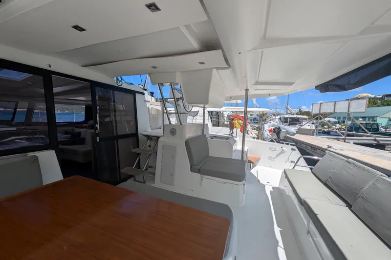 Love A Fayre Yacht Photos Pics 2020 Fountaine Pajot Astrea 42 catamaran interior with seating and table, docked at marina.