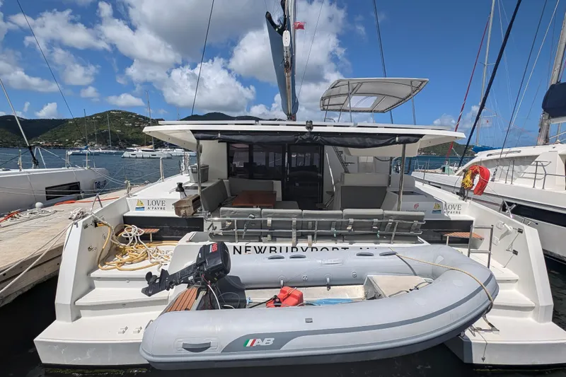 Love A Fayre Yacht Photos Pics 2020 Fountaine Pajot Astrea 42 catamaran docked with inflatable boat, scenic marina view.