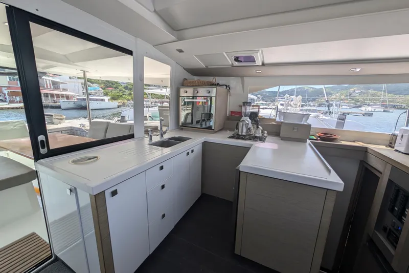 Love A Fayre Yacht Photos Pics Modern kitchen interior of 2020 Fountaine Pajot Astrea 42 catamaran with marina view.