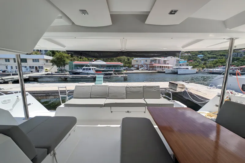 Love A Fayre Yacht Photos Pics 2020 Fountaine Pajot Astrea 42 catamaran interior with marina view, featuring seating and table.