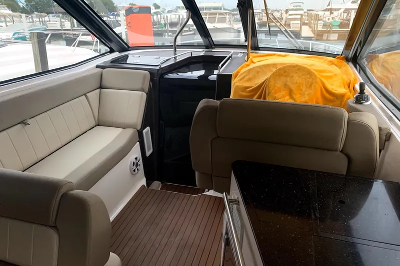 Roe Boat Yacht Photos Pics Interior of 2014 Regal 35 Sport Coupe with beige seating and wood flooring.