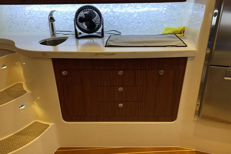  Yacht Photos Pics 2015 Grady-White Express 370 interior with sink, fan, and wooden cabinetry.