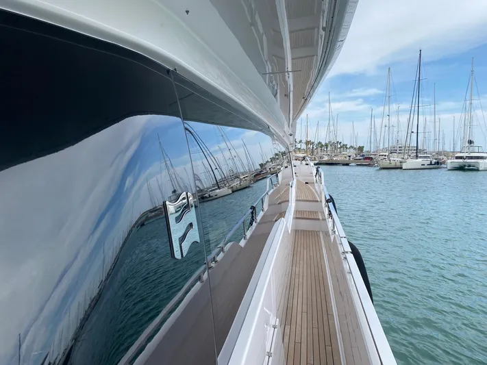 Kayra 1 Yacht Photos Pics Side view of 2024 Ferretti Yachts 780 docked, reflecting marina and sailboats.