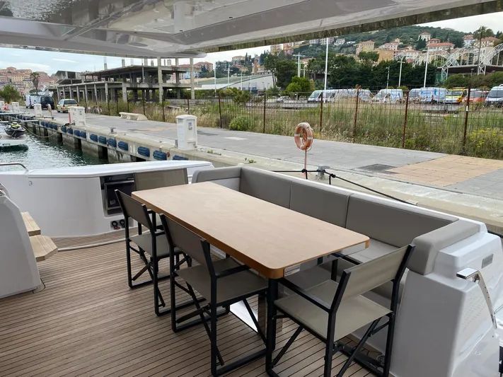 Kayra 1 Yacht Photos Pics Outdoor seating area on 2024 Ferretti Yachts 780, docked at a marina.