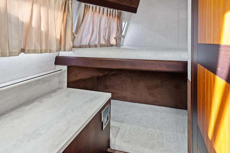  Yacht Photos Pics Interior cabin of 2018 Galeon 640 Fly yacht with bunk beds and curtains.