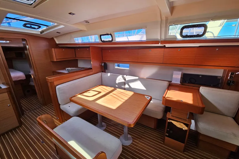 Send Me Yacht Photos Pics Interior of 2018 Dufour 460 Grand Large yacht with wooden furnishings and seating area.