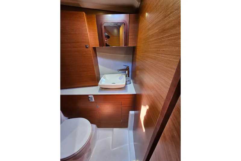 Send Me Yacht Photos Pics Luxurious bathroom in 2018 Dufour 460 Grand Large yacht with modern fixtures and wood paneling.
