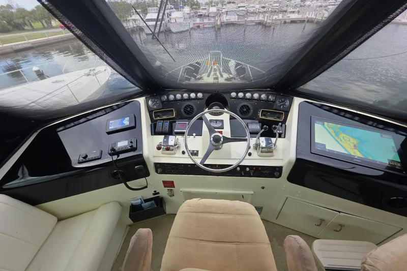 Hatt Trick Yacht Photos Pics Cockpit of 1990 Hatteras 52 Cockpit Motor Yacht with navigation equipment and steering wheel.