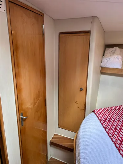 El Caiman Yacht Photos Pics Interior of 1994 Bertram 46 Moppie yacht with wooden doors and cozy bedding.