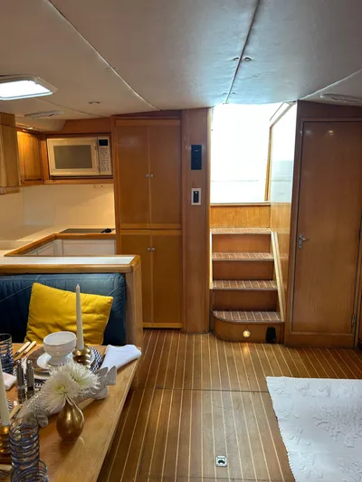 El Caiman Yacht Photos Pics Interior of 1994 Bertram 46 Moppie yacht with wooden flooring and modern kitchen amenities.